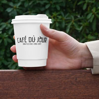 Uma caneca de Café du Jour na mão, pronto para saborear o seu café